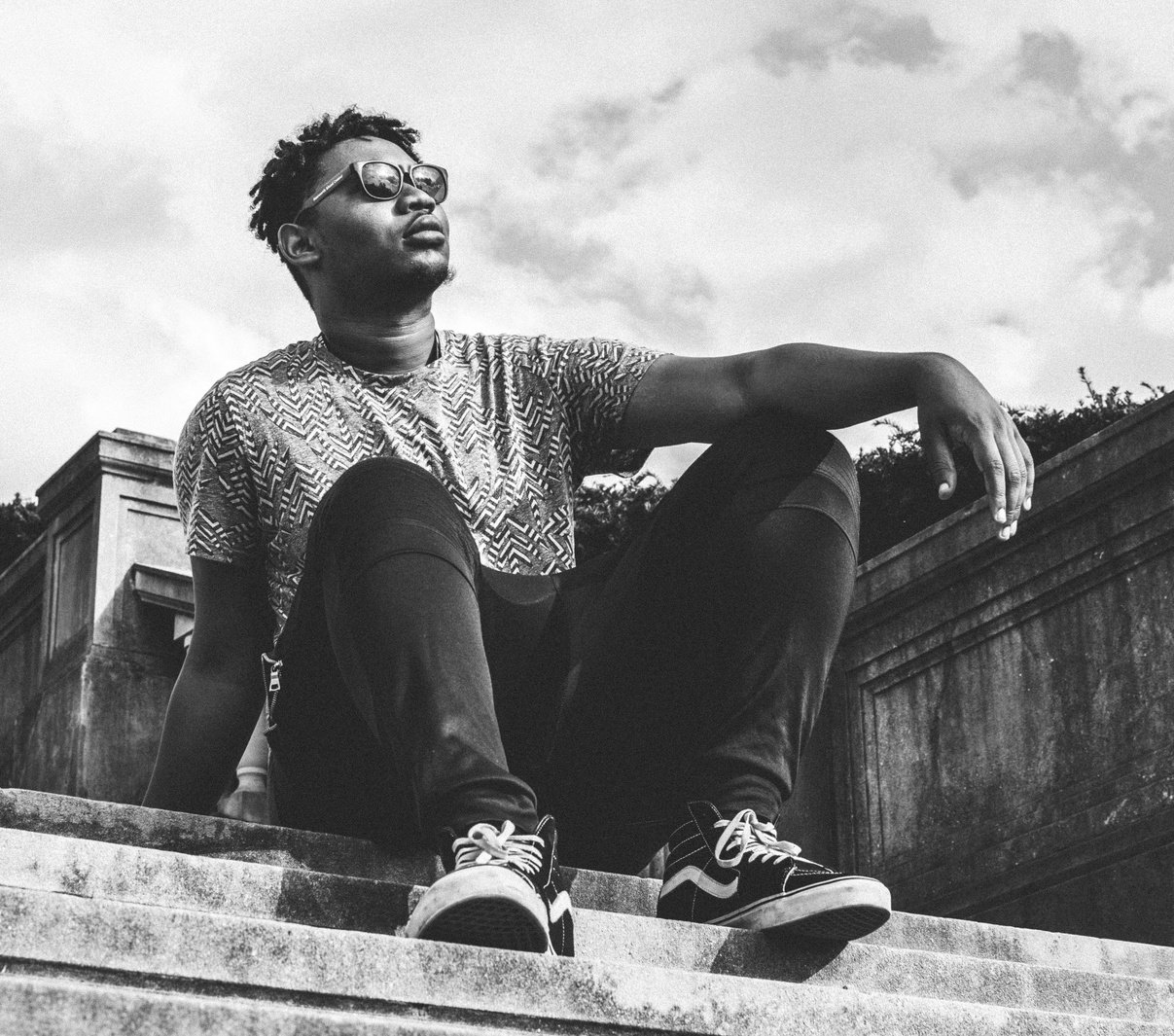 Grayscale Photo of a Man Wearing Pants and Vans Sk8-hi Sneakers